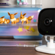 A photo of the Kasa Spot camera perched on a bookshelf, guarding Pokémon figurines